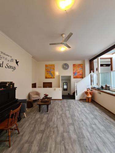una grande camera con soggiorno con pianoforte di Bird Songs Getaway Accommodation a Cabbage Tree Creek