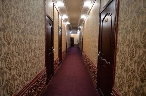 a hallway with a long corridor with doors and a red carpet at Lion Hotel in Astana