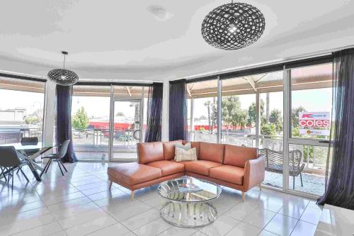 a living room with a couch and a table at Indulge Apartments - CBD in Mildura