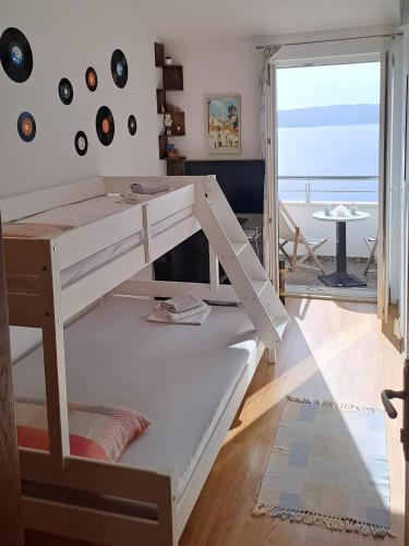 a white bunk bed in a room with a view of the ocean at Kuća za odmor Leptirić in Pisak