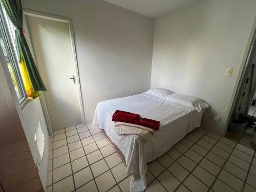 - une chambre avec un lit blanc et des serviettes rouges dans l'établissement Suite aconchegante na Torre, à Récife