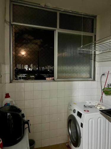 a washing machine in a kitchen with a window at Suite aconchegante na Torre in Recife