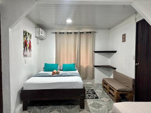 een slaapkamer met 2 bedden en blauwe kussens bij Caribbean View House in Tortuguero