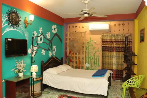 Green Leaf Guest House ColIege Road Sreemongal في سريمانغال: غرفة نوم فيها سرير وتلفزيون