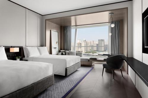 a hotel room with two beds and a chair at JW Marriott Marquis Hotel Shanghai Pudong in Shanghai