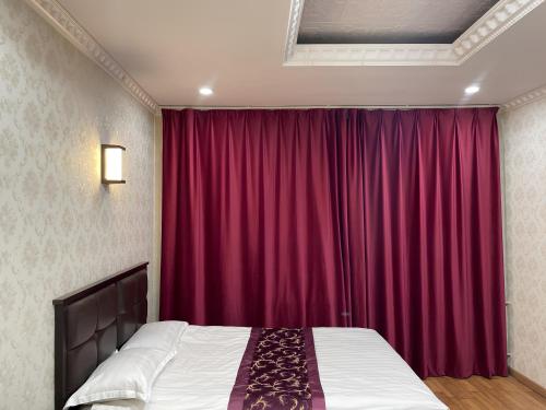 a bedroom with a bed and a red curtain at Khan Hotel Ulaanbaatar in Ulaanbaatar