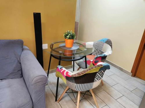 a glass table with chairs and a table with a plant at Elegant & Trendy Apt in a Peaceful Area in Limassol