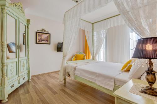 a bedroom with a canopy bed and a window at Cunda Esen Hotel in Ayvalık