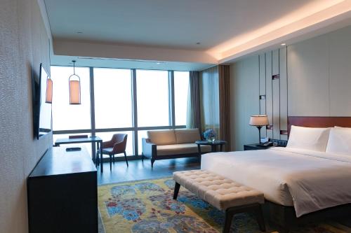 a hotel room with a bed and a living room at Grand Hyatt Changsha-Close to Helong Sports Center in Changsha