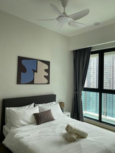 a bedroom with a white bed with a ceiling fan at Ooak Residence in Mont Kiara, Kuala Lumpur in Kuala Lumpur