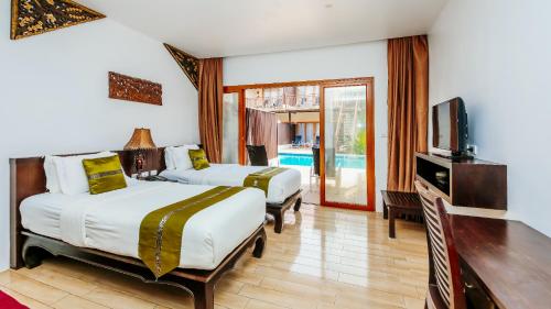 a hotel room with two beds and a television at Blue Bay Resort - Near Phuket & Krabi in Ko Yao Yai