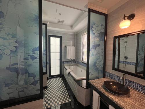 ein Badezimmer mit einem Waschbecken und einer Badewanne in der Unterkunft Sun Villa Thanh Liên Wyndham Vườn Vua Resort & Villas in Ðồng Phú