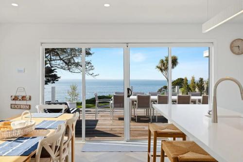 a kitchen and dining room with a view of the ocean at The Waters Edge by Ready Set Stay in San Remo