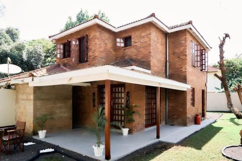 uma casa de tijolos com um toldo num quintal em Olive Home Arusha em Nasulo