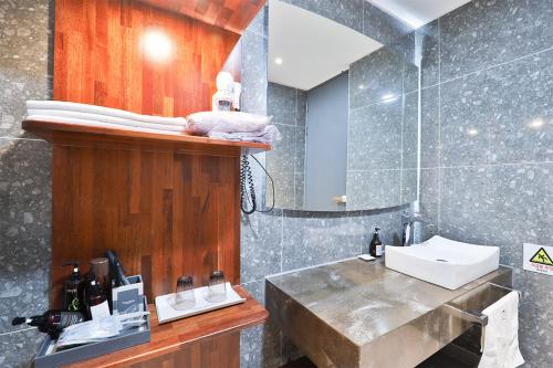 a bathroom with a sink and a mirror at HOTEL YUNA Business in Busan