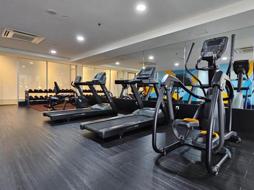 a gym with several treadmills and elliptical machines at Days Hotel & Suites by Wyndham Fraser Business Park KL in Kuala Lumpur