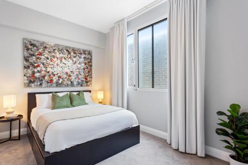 a bedroom with a bed and a painting on the wall at Potts Point l 2 Bedroom Stylish Retreat in Sydney