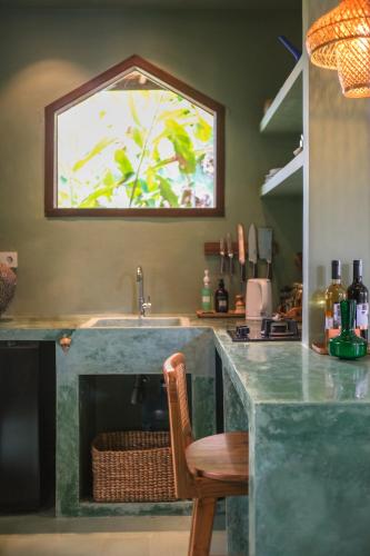 a kitchen with a counter with a sink and a chair at Rumah Senang - Walk to Beach in Balian