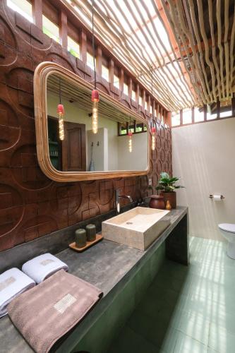 a bathroom with a large sink and a mirror at Rumah Senang - Walk to Beach in Balian
