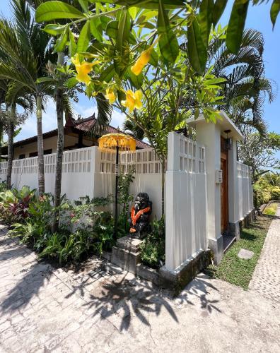 a white fence in front of a house at Rumah Senang - Walk to Beach in Balian