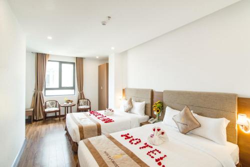 Habitación de hotel con 2 camas con corazones rojos. en Ngọc Lan Hotel en Da Nang