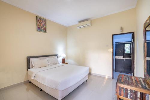 ein Schlafzimmer mit einem großen weißen Bett und einem Fenster in der Unterkunft Green Cottage Lembongan by ABM in Nusa Lembongan