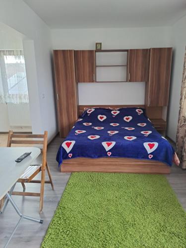 1 dormitorio con cama y alfombra verde en Vila Bulgaru, en Cumpăna