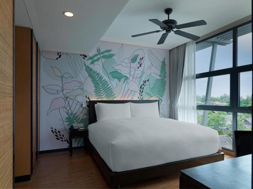 a bedroom with a white bed and a plant wall at Avani Plus Mai Khao Phuket Suites in Mai Khao Beach