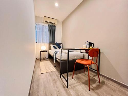 Un dormitorio con una cama, una mesa y una silla. en K2 Guesthouse, en Singapur