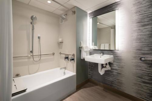 een badkamer met een wit bad, een wastafel en een bad tubermott bij Torrance Marriott Redondo Beach in Torrance