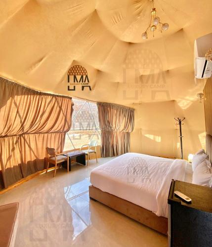 - une chambre avec un grand lit dans une tente dans l'établissement Lma Luxury Camp, à Wadi Rum