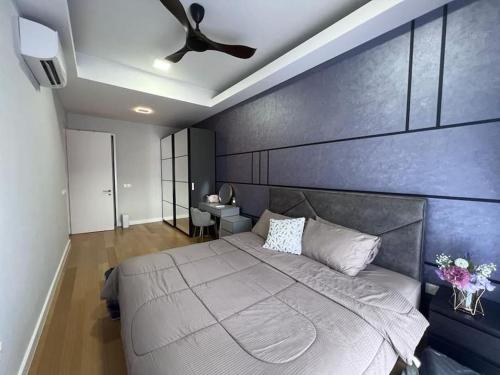 a bedroom with a large bed with a blue wall at Sentral Suites Kuala lumpur By Leyla 3BR suites 8 pax in Kuala Lumpur