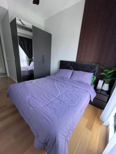 a bedroom with a bed with a purple comforter at Sentral Suites Kuala lumpur By Leyla 3BR suites 8 pax in Kuala Lumpur