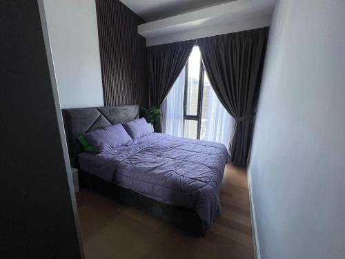 a bedroom with a bed with purple sheets and a window at Sentral Suites Kuala lumpur By Leyla 3BR suites 8 pax in Kuala Lumpur
