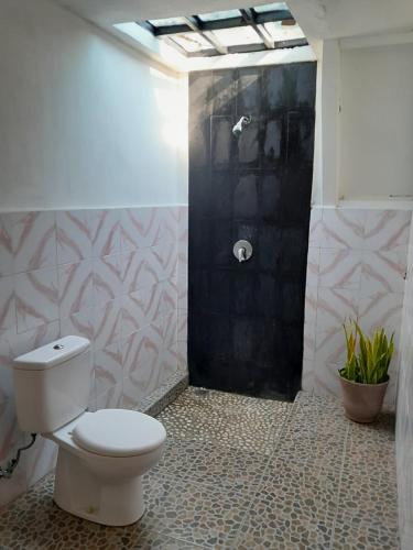 uma casa de banho com WC e uma porta preta em Florine's Garden em Gili Air