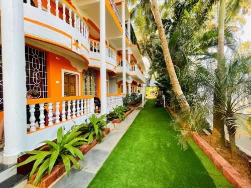 un patio de un edificio con palmeras y césped en Samantha Inn Beach Resort, en Arambol