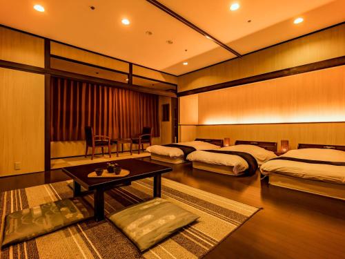 una camera d'albergo con due letti e un tavolo di Yukai Resort Premium Seiunkaku ad Awara