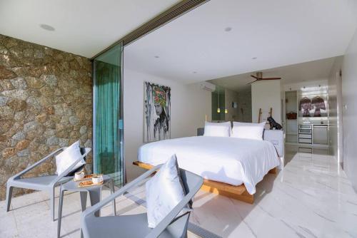 a bedroom with a large bed and a stone wall at So Paradise Villa 4 bedrooms in Koh Samui 