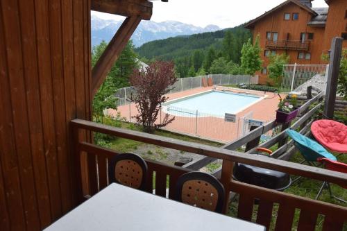 a view of a pool from the balcony of a house at LES PETITS ETERLOUS Appartement T3 36m2 à Puy St Vincent 1800 Alpes du sud 6 personnes parking privé couvert in Puy-Saint-Vincent