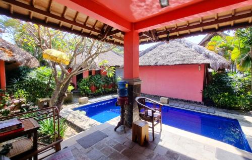 a house with a swimming pool in a yard at Flash Back Bungalow in Sanur