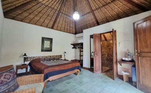 a bedroom with a bed and an open door at Flash Back Bungalow in Sanur