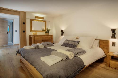 a bedroom with a large bed with towels on it at Chalet Manoe - OVO Network in Manigod