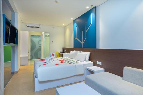 een slaapkamer met een groot bed en een bank bij 1O1 URBAN Jakarta Pemuda in Jakarta