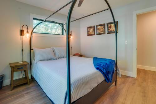 a bedroom with a four poster bed with blue sheets at Higgins Lake Vacation Rental with Lake Views and Deck! in Roscommon