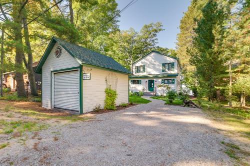 a house with a garage and a driveway at Higgins Lake Vacation Rental with Lake Views and Deck! in Roscommon