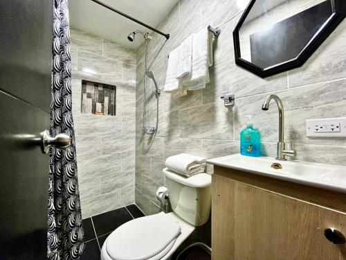 uma casa de banho com um WC, um lavatório e um chuveiro em Edificio Victory Medellin - Apartamentos Acogedores y Equipados 100MB Wi-Fi, Central & Terraza Compartida em Medellín
