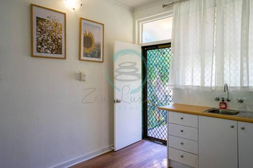 NightcliffNightcliff Nest - Stylish 2BR Apt Near Foreshore的厨房设有门、窗户和水槽