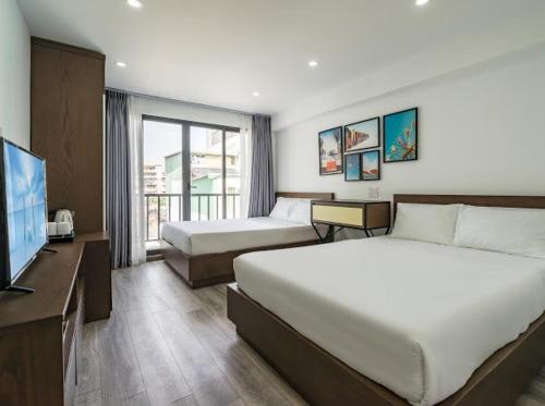 Habitación de hotel con 2 camas y TV de pantalla plana. en AILEN BOUTIQUE HOTEL en Ho Chi Minh