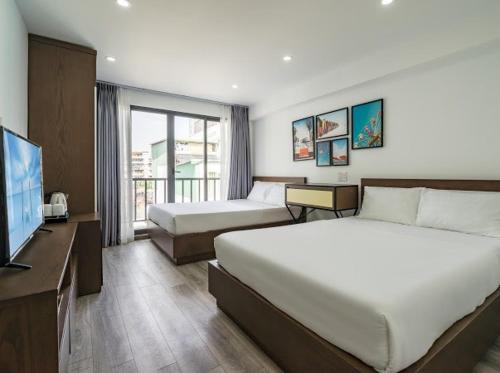 Una habitación de hotel con dos camas y un televisor de pantalla plana. en AILEN BOUTIQUE HOTEL, en Ho Chi Minh