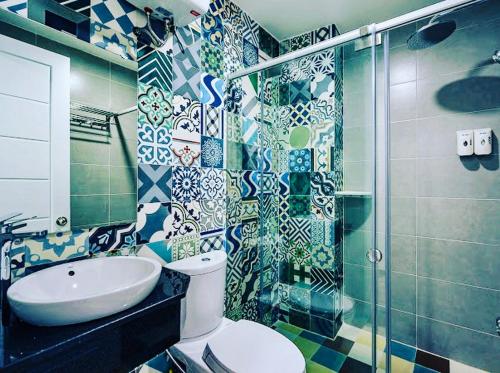 y baño con aseo, lavabo y ducha. en AILEN BOUTIQUE HOTEL en Ho Chi Minh